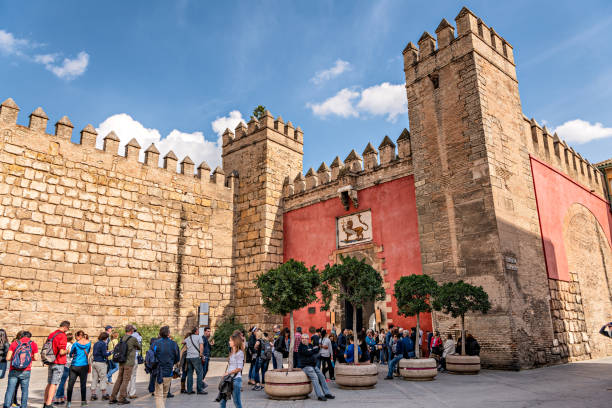 los turistas esperan en línea para visitar el histórico alcázar real de sevilla. - plaza de espana sevilla town square seville fotografías e imágenes de stock