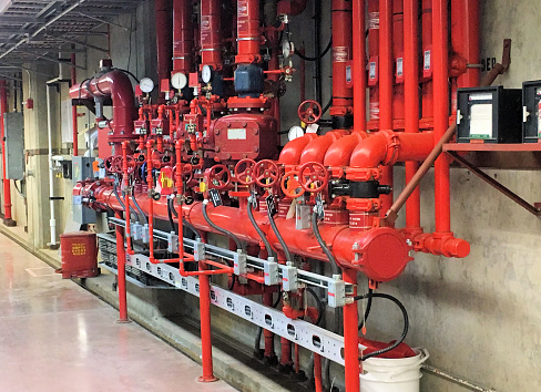 An automatic system of red metal pipes, sensors and valves for fire safety at an industrial workplace.