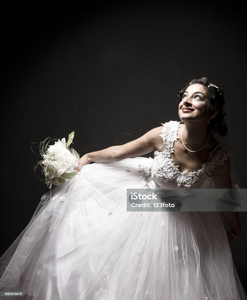 Sorridente sposa con abito da sposa e Courtseying - Foto stock royalty-free di Sfondo nero