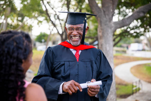 senior hombre negro en la graduación de hablar con su familia - old master fotografías e imágenes de stock