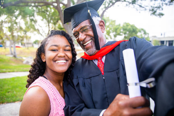 istock Senior black man at graduation taking a selfie with his daughter 1082036836