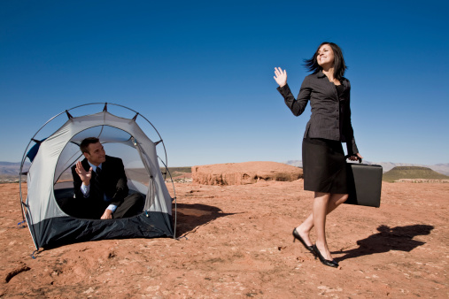 business couple waving goodbye at tent