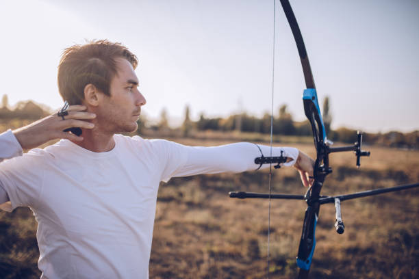 istock Young man training archery outdoors 1082038348