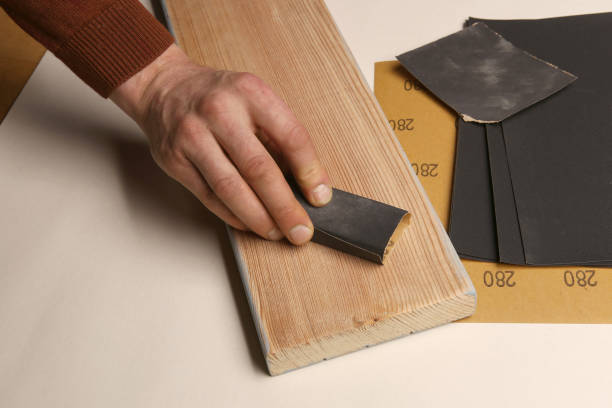 istock Man hand smoothing wood board using sandpaper. 1082040496