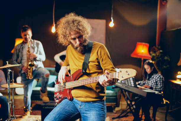 istock Bass guitarist playing guitar while sitting on the chair. 1082043776