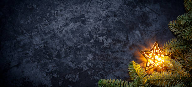 estrela de natal dourada em metal escuro - holiday background galho de árvore do abeto - christmas tree fir tree branch christmas - fotografias e filmes do acervo