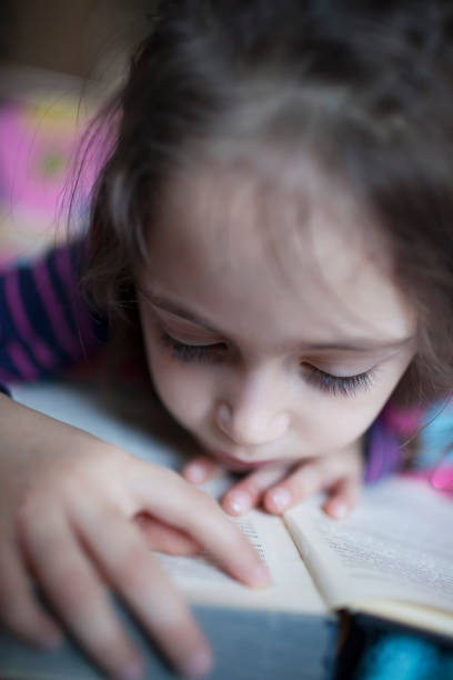 istock Little girl 6 years old reading a book 1082048840