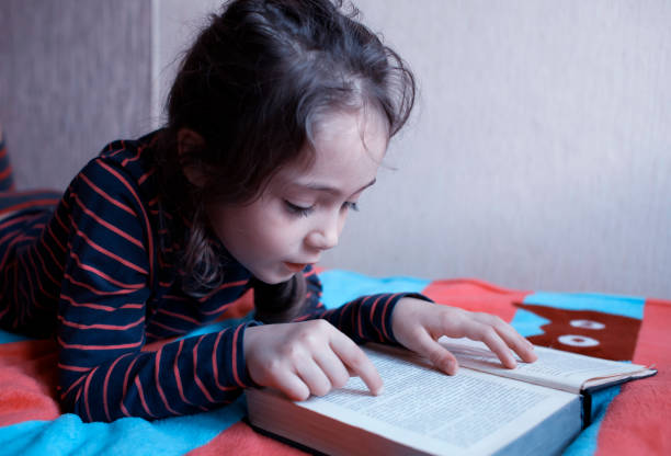 istock Little girl 6 years old reading a book 1082048888
