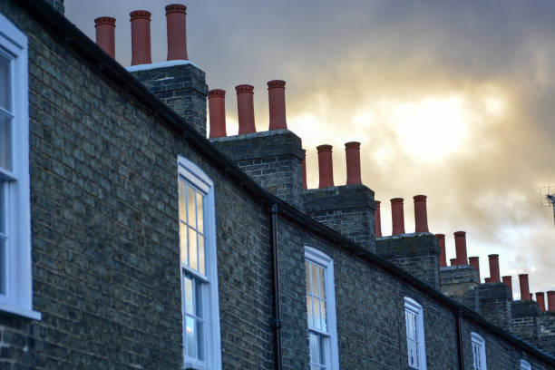 Row of terraced houses with chimneys and overcast sky