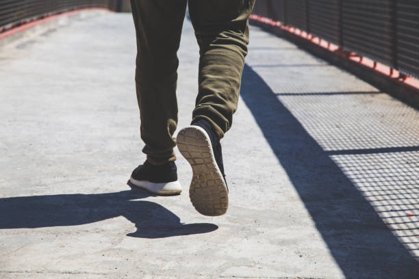 istock Low Section Of Man Walking On Footpath 1082064104