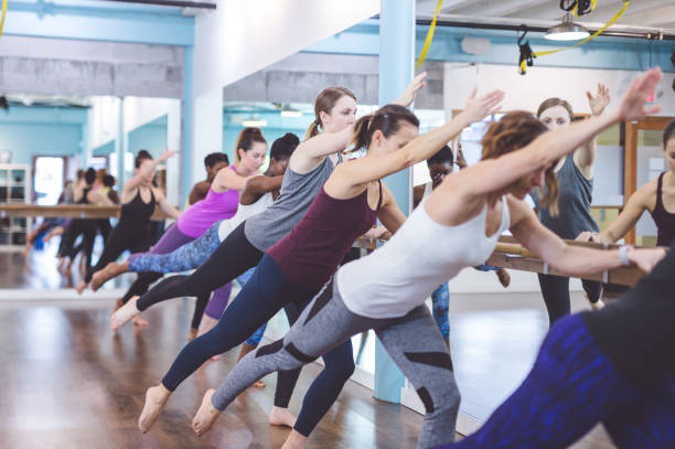 istock Instructor leads a multiethnic group of women through a barre workout 1082064560