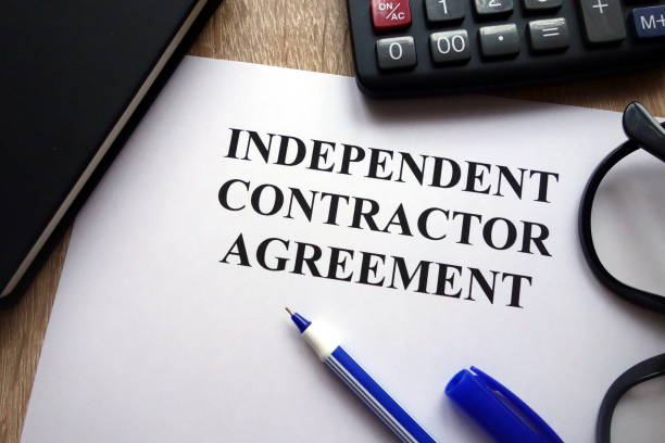 Independent contractor agreement Independent contractor agreement, pen, glasses and calculator on desk independent stock pictures, royalty-free photos & images