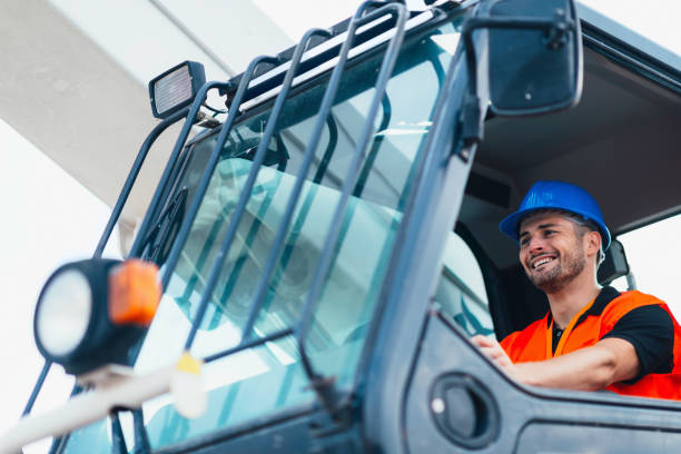 istock Low Angle View Of Smiling Manual Worker Driving Vehicle 1082069072