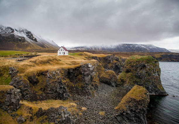 istock Famous building under the Snaefellsjokull volcano and glacier in Arnarstapi, Snaefellsnes peninsula, Iceland. Dramatic icelandic landscape, lonely house on the volcanic cliffs seacoast. Icelandic 1082082216