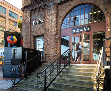 San Francisco Mozilla headquarters on the Embarcadero. Someone is entering the building and the Firefox logo is visible on a column by the entrance.