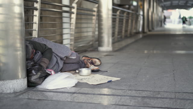 Panning: Homeless sleeping on the footpath.