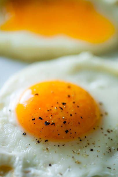 Fried egg sunny side with condiments and salt. Fried Egg Sunny Side Up Macro Close-up. Food background and texture. Morning light. Breakfast