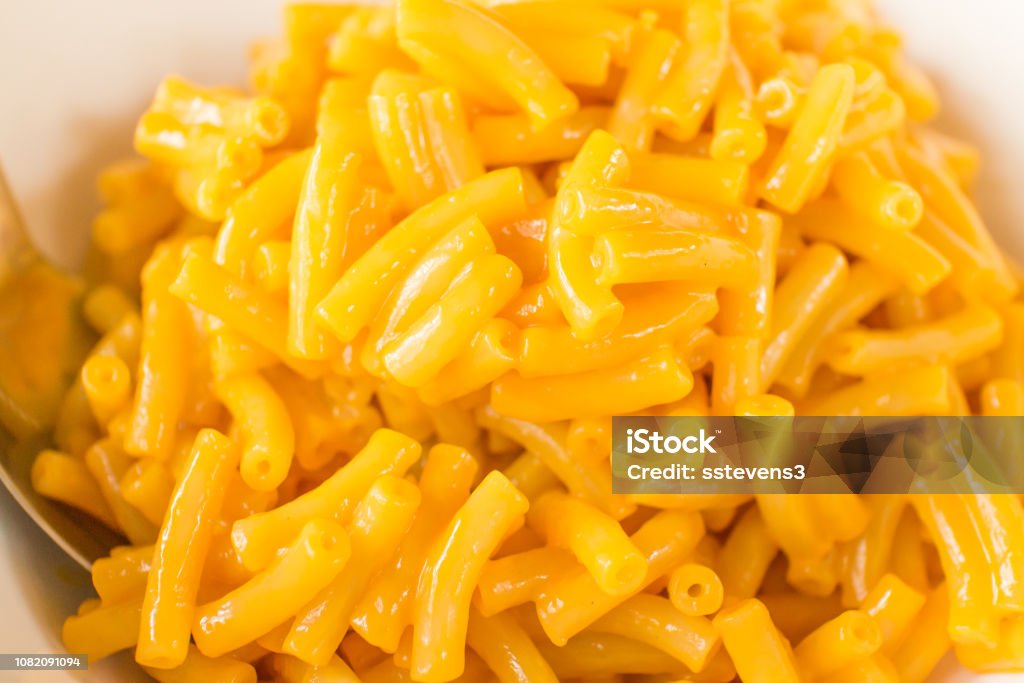 Macaroni and Cheese Macaroni and cheese in a white bowl with a spoon. Macaroni and Cheese Stock Photo