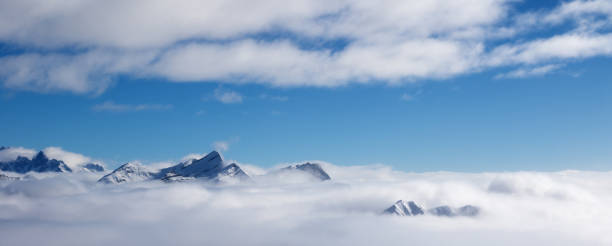 istock Snowy sunlight mountains in fog at nice sun day 1082093584