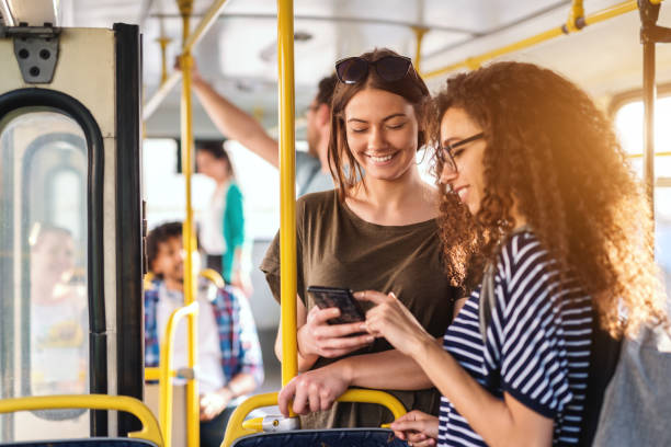 istock Two friends looking in phone while standing on a bus. 1082094032