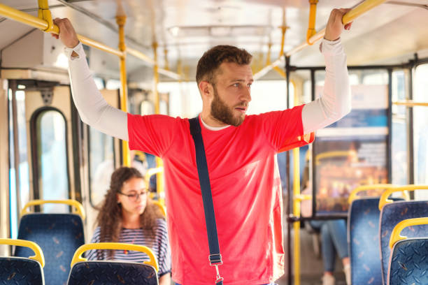 istock Young man standing in a bus, holding to hand-grip , looking trough window, thinking. 1082095770