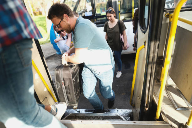 istock Small Group of people entering bus. Selective focus on Man with luggage. 1082096958