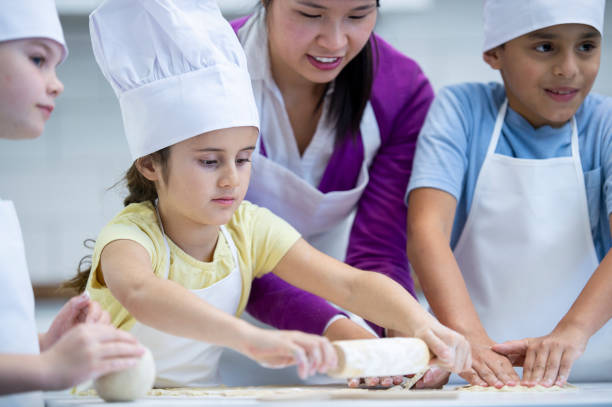 istock Little girl rolling dough 1082098344