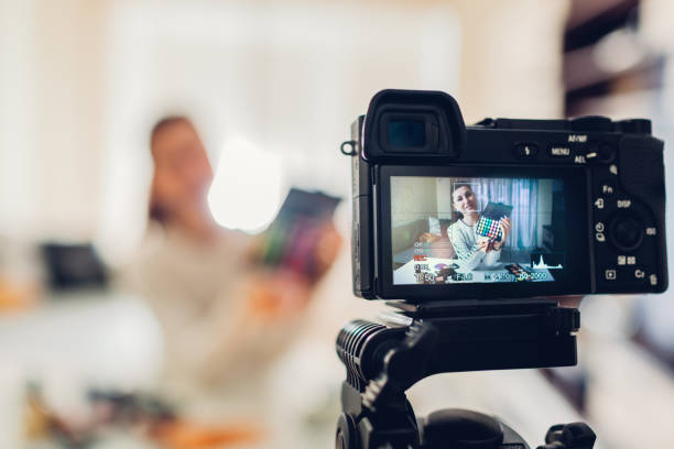 istock Young woman professional beauty vlogger or blogger recording make up tutorial using camera and tripod 1082098496