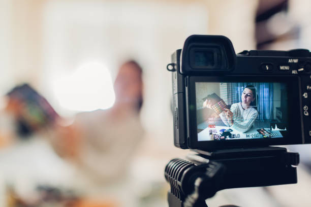 istock Young woman professional beauty vlogger or blogger recording make up tutorial using camera and tripod 1082098500