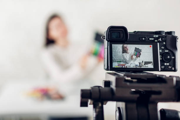 istock Young woman professional beauty vlogger or blogger recording make up tutorial using camera and tripod 1082098510