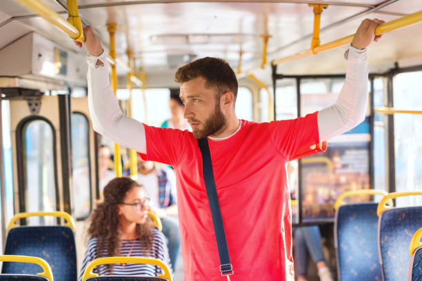 istock Man holding to a handrails in a bus, looking trough window. 1082098564