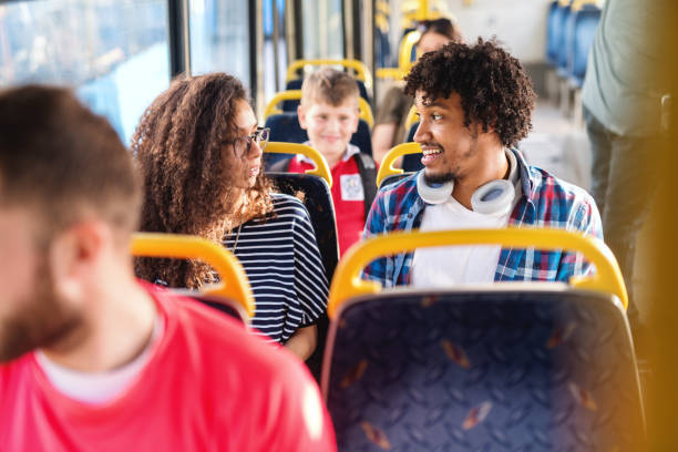 jung, lächelnd multikulturelles paar sprechen während der sitzung in der city-bus. - pair cheerful happiness heterosexual couple stock-fotos und bilder