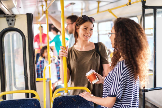 istock Two girls in a bus standing, chatting and smiling. 1082098802