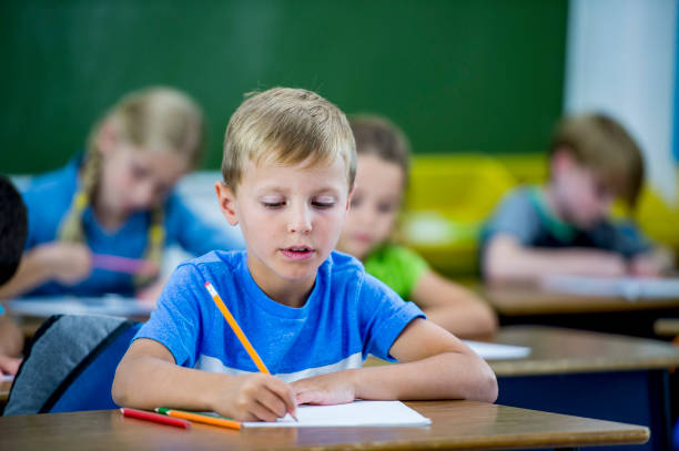 istock Primary school boy writing at a desk 1082102096