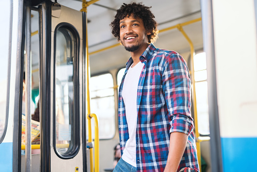 Chico afroamericano sonriente joven bajar del autobús. photo