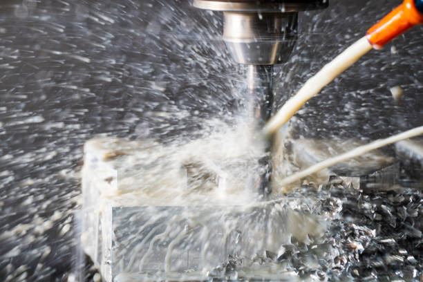 istock CNC Machine tool cutting metal with coolant spray flying in a machine shop. 1082104142