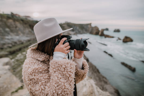 istock Young woman taking a picture with a modern DSLR camera 1082106000