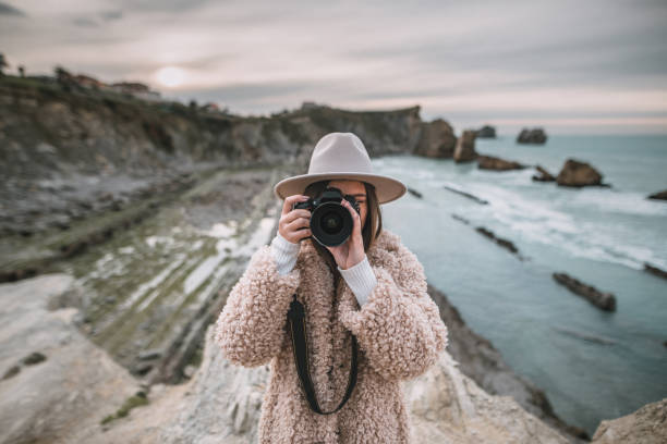 istock Young woman taking a picture with a modern DSLR camera 1082108056