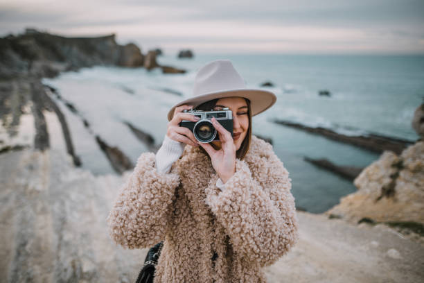 istock Young woman using a vintage camera 1082117114