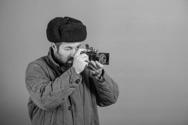 Portrait of beard African American professional cameraman with glasses in the studio.