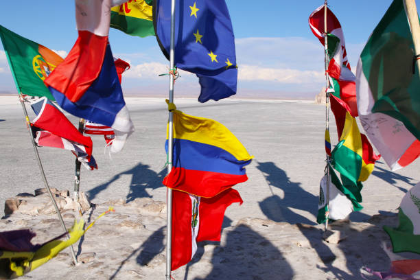 флаги в соляной пустыне салар-де-уюни в боливии. - national flag flag global communications sky стоковые фото и изображения
