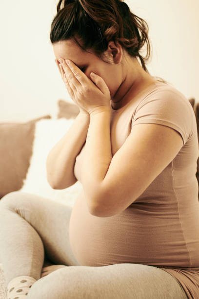 istock Sad pregnant woman sitting on sofa and crying. 1082148066