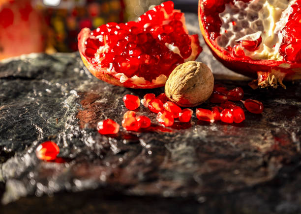 istock Pomegranate and pomegranate seeds with nut on the black natural stone plate 1082171516
