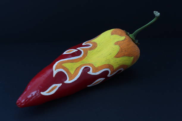 istock Red Chilli Pepper With Painted Fire On Black Craft Paper Background 1082175998