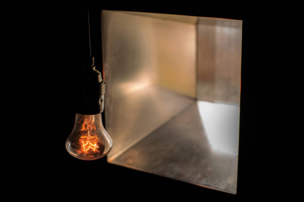 istock Glow lamp bulb without lamp shade in the dark opposite to a square window 1082178346