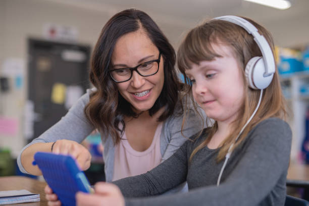 istock Teacher helping a first grader in her classroom 1082179882