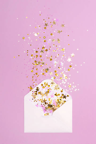 istock Golden and pink confetti scattered from envelope on pastel purple background. 1082183080
