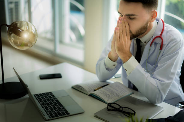 istock Doctors are making serious faces and stressed about work. The doctor is feeling a headache at work and feeling stressed in treating the patient. 1082185842