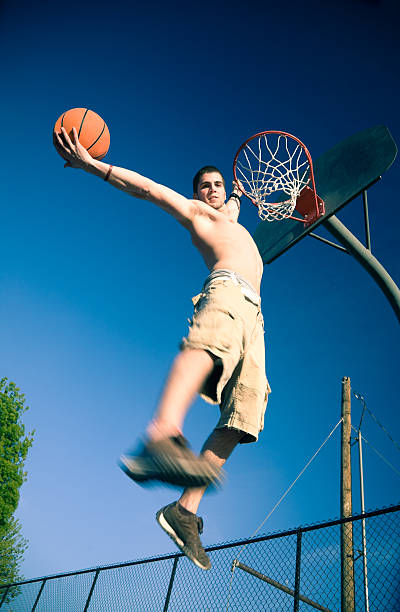 istock Young Man Dunking Basketball in Net on Court 108219137