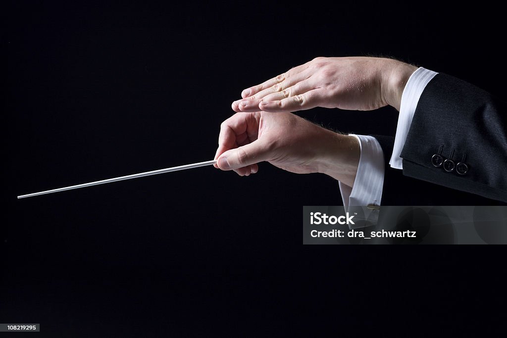 Close-up of Orchestra Conductor's Hands, Isolated on Black Conductor's hands Orchestra Stock Photo